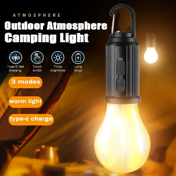 A black outdoor atmosphere camping light with a warm yellow glow, shown next to a Type-C charging cable.