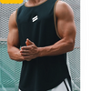 A muscular man wearing a black sleeveless sports tank top with white stripes, posing outdoors.