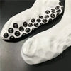White anti-slip silicone grip football socks with black circular patterns