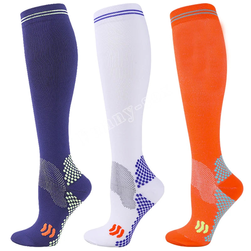 Three pairs of medical grade compression socks in navy blue, white, and orange showing different levels of compression.