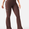 A model wears high-waisted brown flared fitness pants with side pockets.