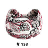 Un bandeau en coton stretch floral rose et noir style bohème, noué en nœud.