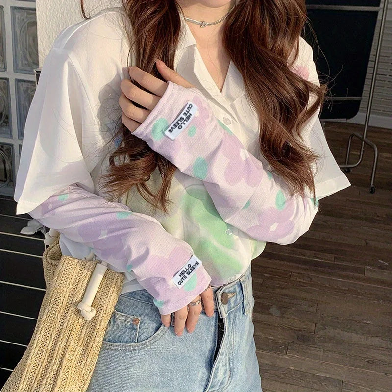 A woman wearing white shirt and denim jeans with purple floral ice silk sun protection arm sleeves.