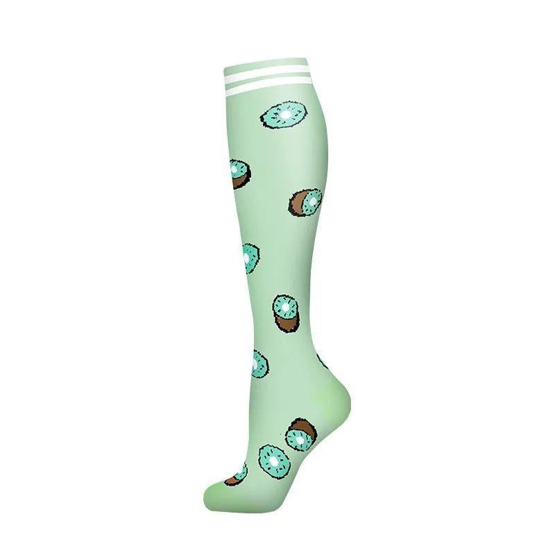 A pair of light green compression socks with a pattern of fruit illustrations.