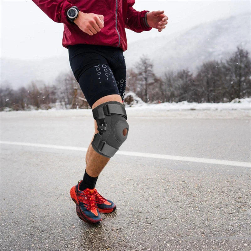 Eine Person läuft auf Asphalt, trägt eine schwarze Knieschiene und rote Sportkleidung.