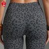 Gros plan d'une femme portant des shorts de yoga à taille haute à imprimé léopard gris foncé.