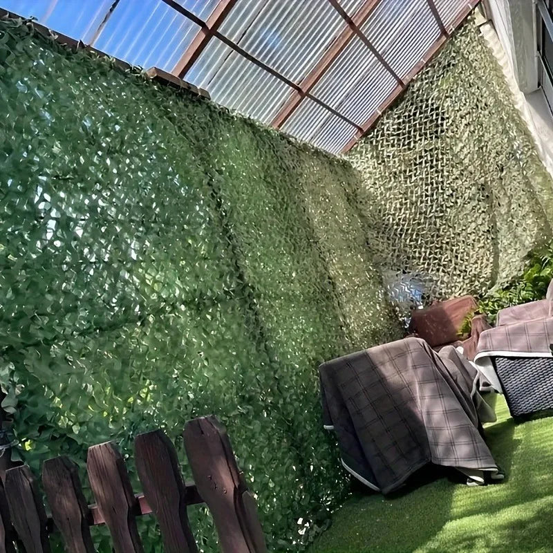 A dense green hedge wall covered in climbing vines next to a wooden fence and a corrugated metal roof structure.