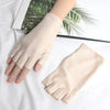 A pair of beige thin stretch elastane gloves shown on a hand, resting on a white surface.