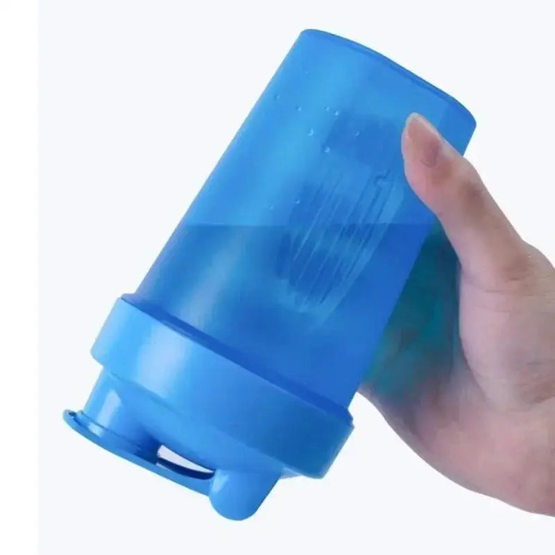 A hand is holding a transparent blue leakproof protein shaker bottle.
