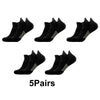 Five pairs of black performance compression sports socks laid out for display.