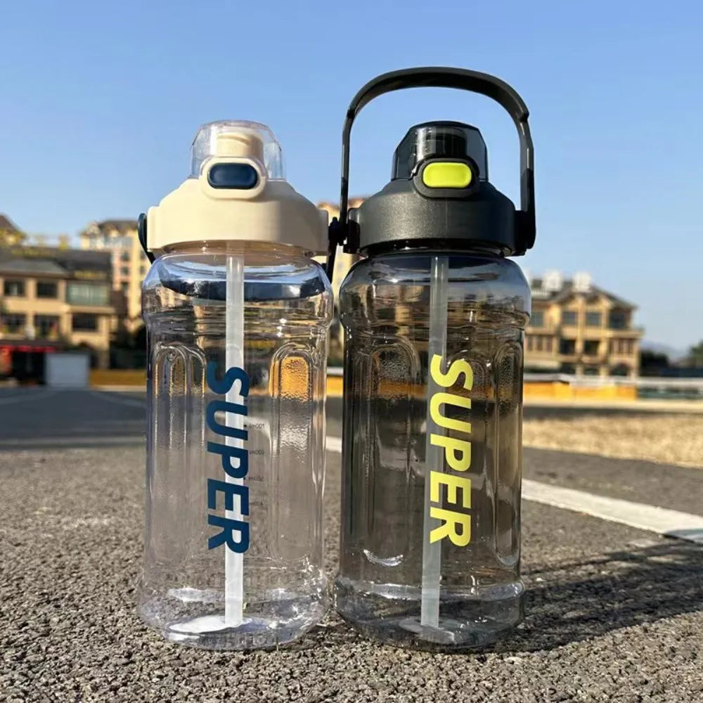 Two clear insulated sports water bottles with black lids and white straws resting on asphalt.