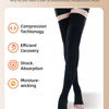 A pair of black professional compression socks being worn on a person's lower leg.