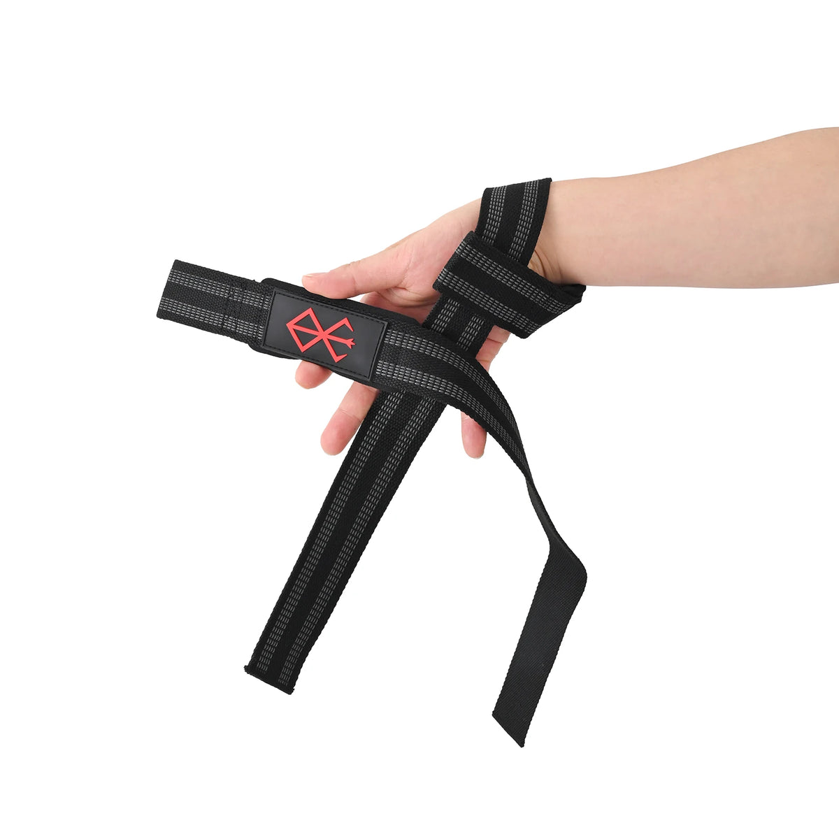 Une main porte un bandeau de poignet noir robuste avec un logo rouge pour l'entraînement en force.