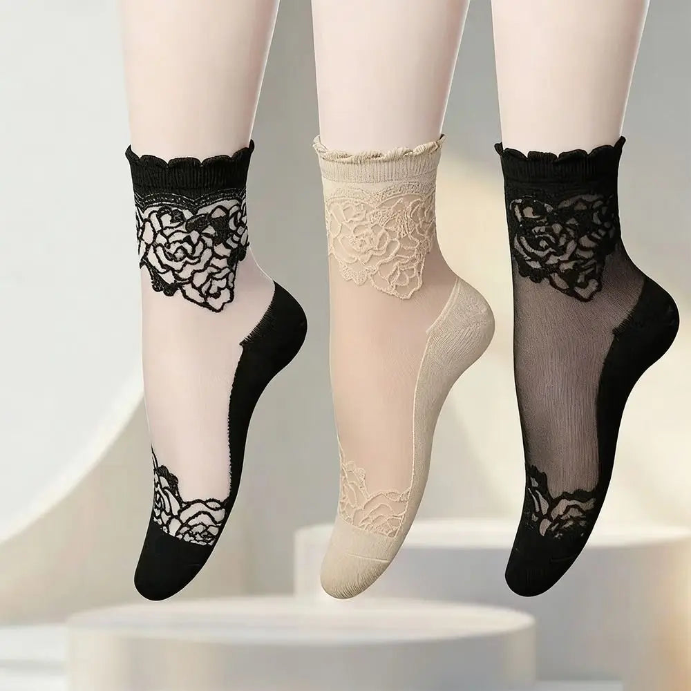 A set of sheer invisible lace socks in black and beige, displayed on a white surface.