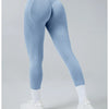 A person wearing light blue high-waist yoga leggings and white socks, shown from the side.