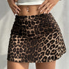 A model wears a brown and black leopard print casual mini skirt with a white crop top.