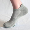 Nahaufnahme von hellgrauen Socken, die am Knöchel getragen werden.
