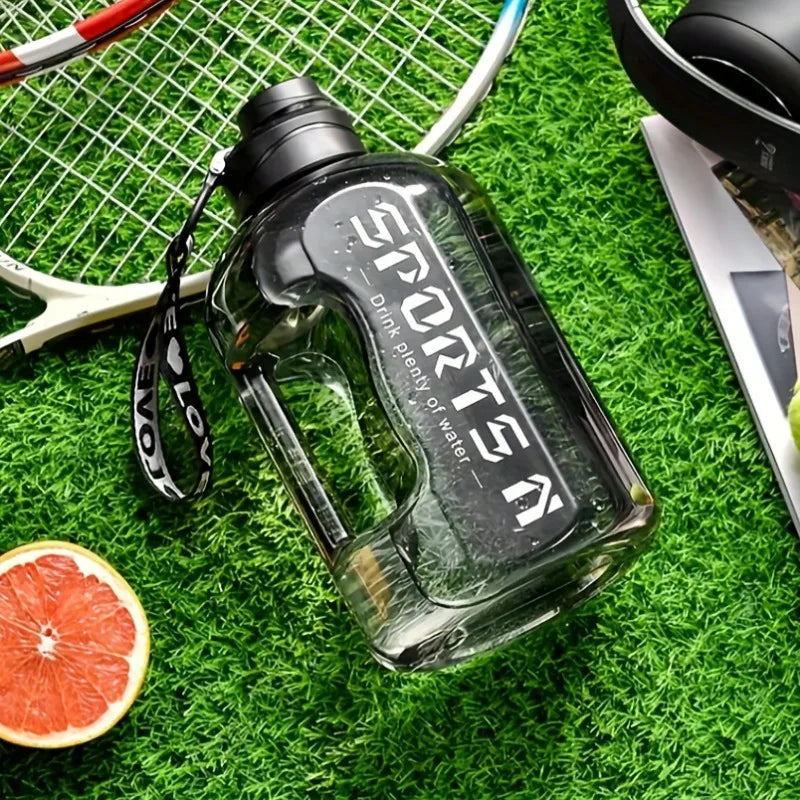 Klare wiederverwendbare Sportflasche mit schwarzem Deckel auf grünem Kunstrrasher neben einer Orangenscheibe.