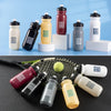 A collection of durable sports water bottles in various colors including red, yellow, black, and white, displayed on a surfac