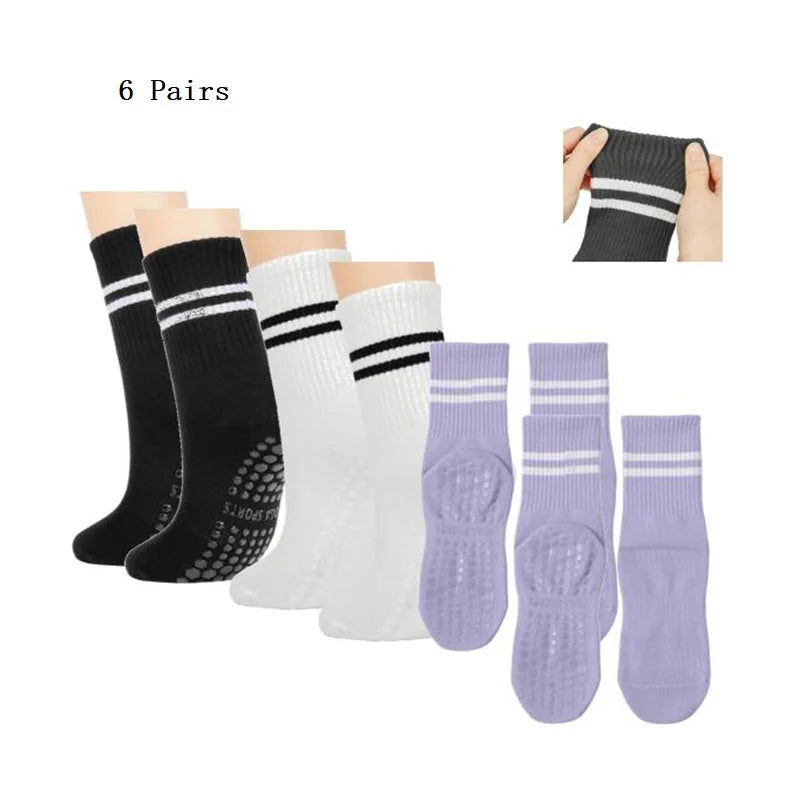 Six pairs of black, white, and purple grip socks for yoga and barre
