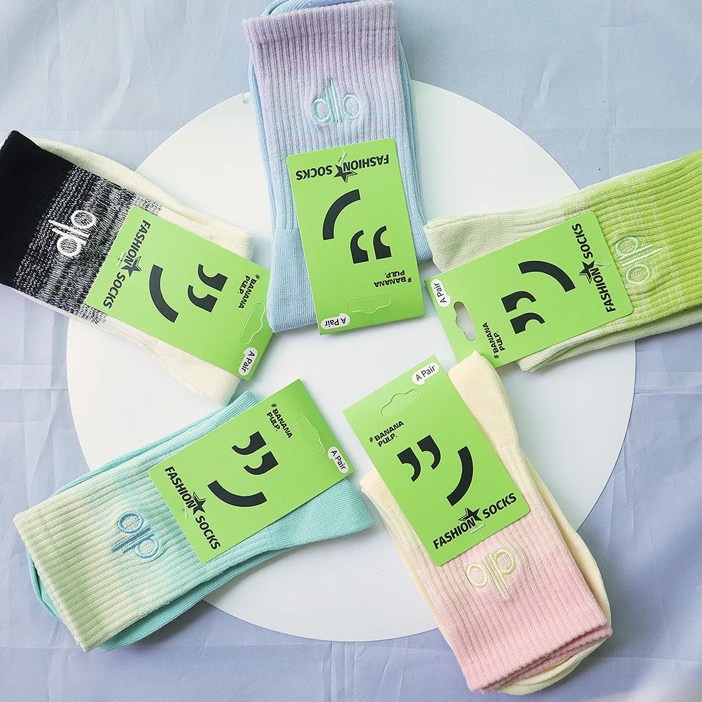 A collection of pastel colored socks, including purple, light blue, and green, displayed on a white surface.