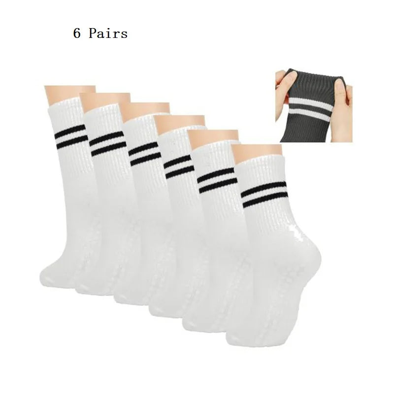 Six pairs of white grip socks with black stripes shown on a hand.