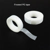 A roll of frosted PE tape with a strip unwound, used for eyelash extension application.