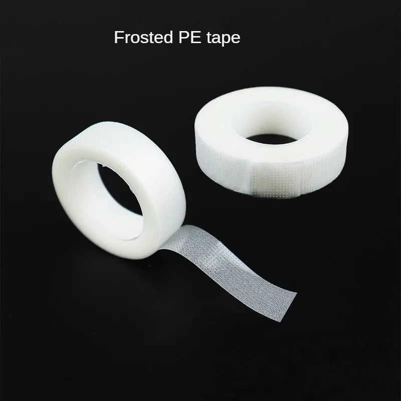 A roll of frosted PE tape with a strip unwound, used for eyelash extension application.