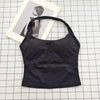 Black seamless sports camisole top laid on a white grid with a photo in the background.