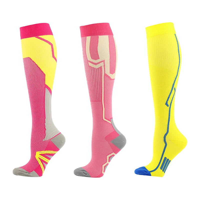 A set of three compression socks in pink, yellow, and gray for athletes and medical use.