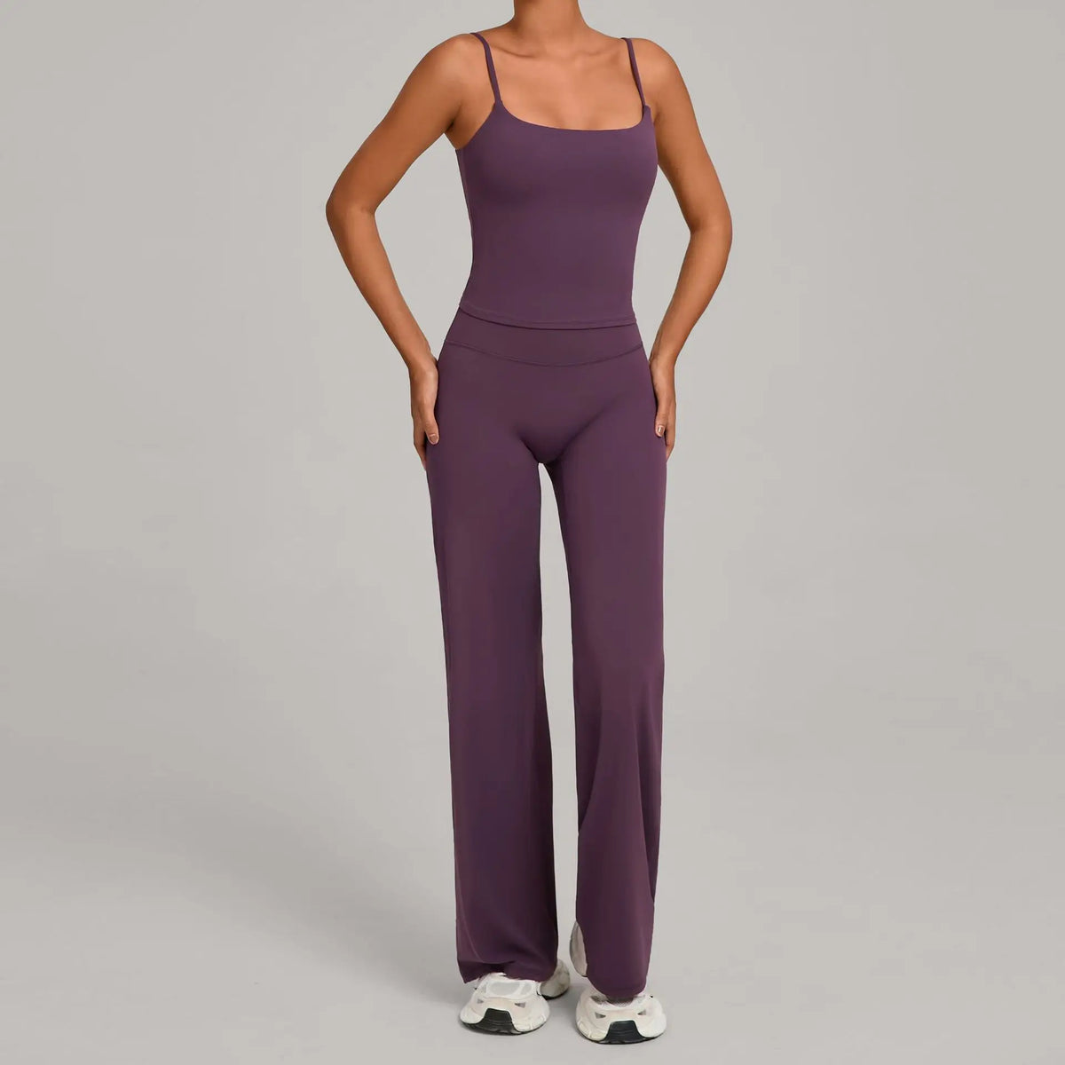 A woman wearing a purple high-waist yoga and fitness tracksuit set.