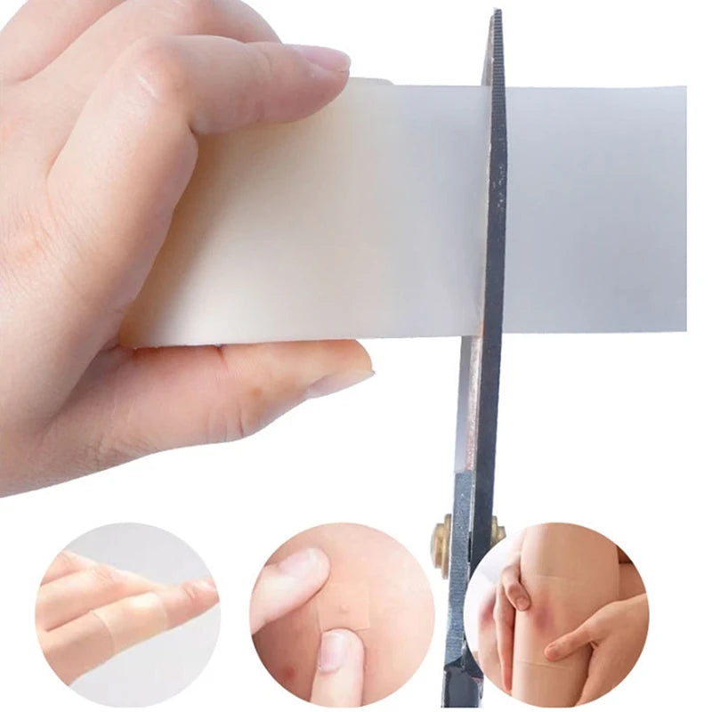 A hand holds a clear hydrocolloid wound care patch next to a surgical blade and several patches for skin healing.