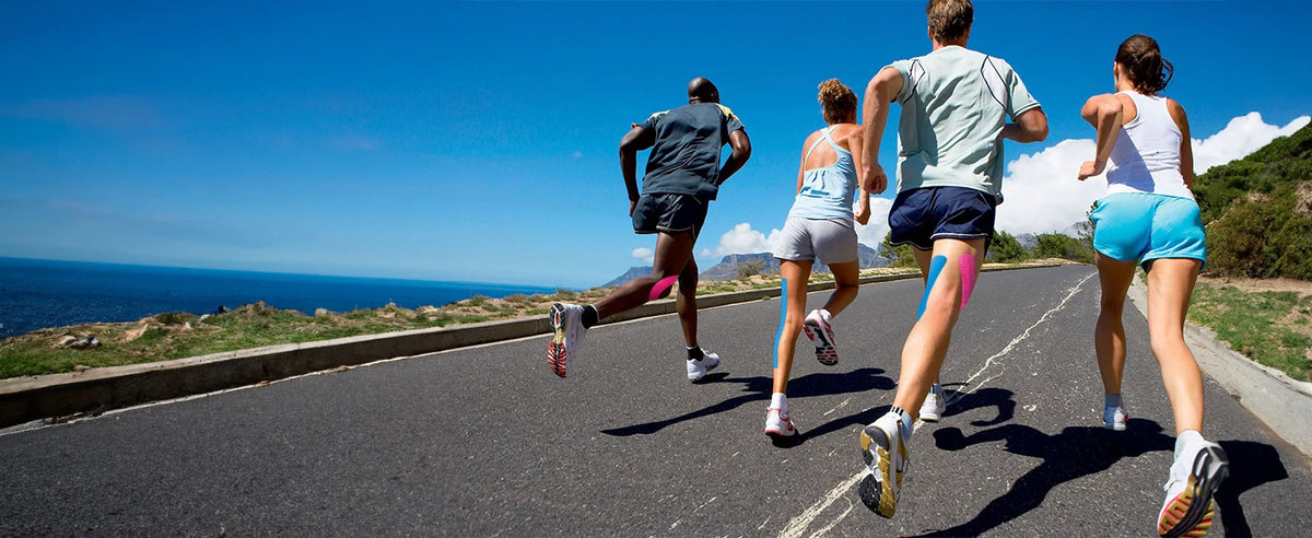 Three people run on a road with a railing under a clear blue sky.