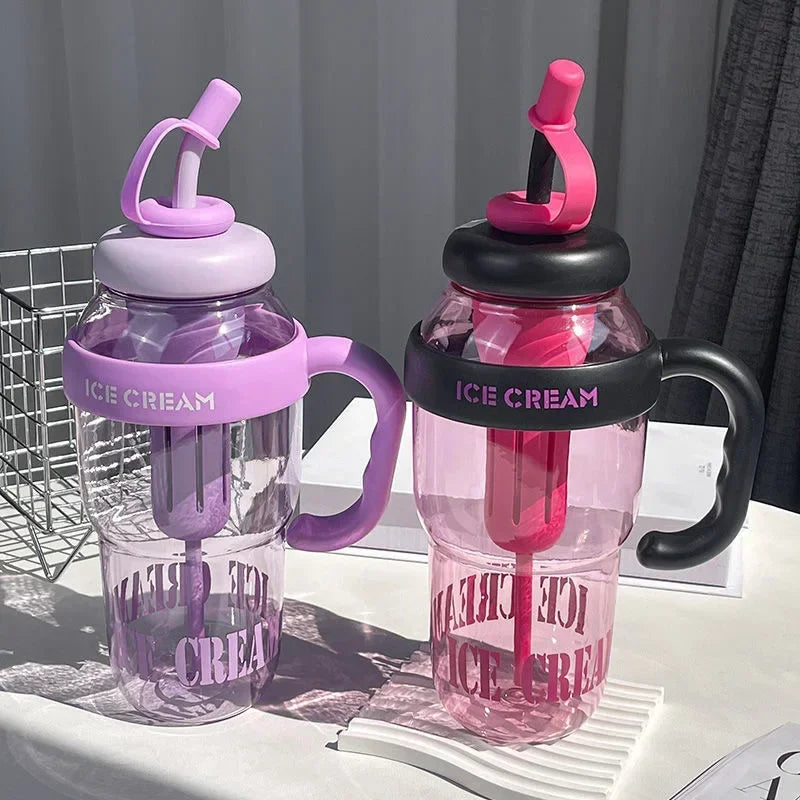 Two clear plastic drinking cups with pink and purple lids and black handles are displayed on a white surface.