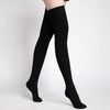 Black medical compression stockings being worn on a person's legs.