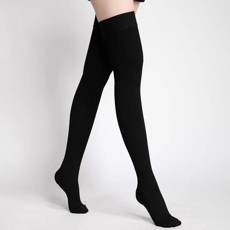 Black medical compression stockings being worn on a person's legs.