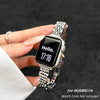 A hand holds a black smartwatch with a stainless steel band, displaying the time 17:16.