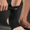 A person's ankle is shown wearing a black Breathable Ankle Support Brace for Injury Recovery.