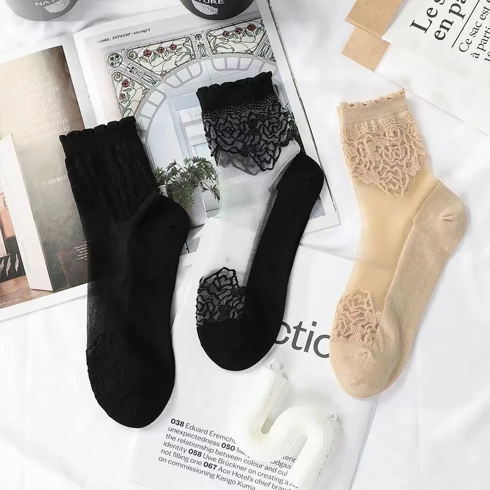 A collection of black and beige sheer invisible lace socks displayed on white paper.