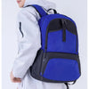 A young man is shown wearing a white jacket and gray pants while carrying a blue basketball backpack.