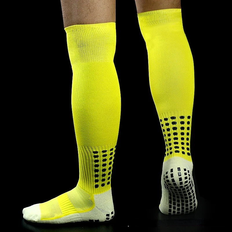 A pair of neon yellow long football training socks with black dot patterns and white trim.