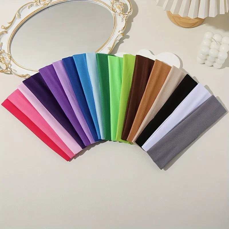 Eine Sammlung farbenfroher elastischer Stirnbänder in verschiedenen Violett-, Blau-, Grün-, Pink- und Brauntönen auf einem he