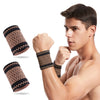 A muscular man wearing copper compression wrist sleeves for pain relief.