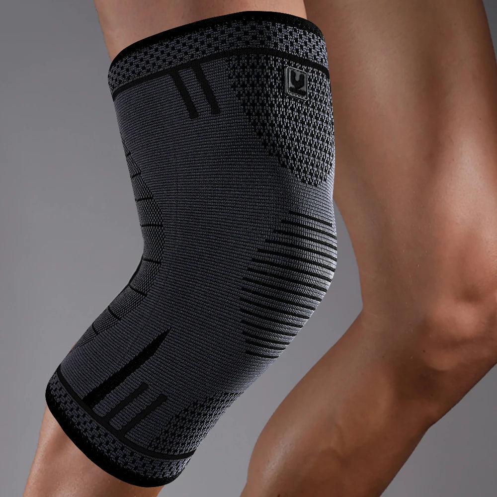 Black compression knee support sleeve worn on a person's leg.