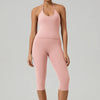 Eine Frau trägt ein zweifaches pinkes Yoga-Activewear-Set aus Tanktop und Leggings.