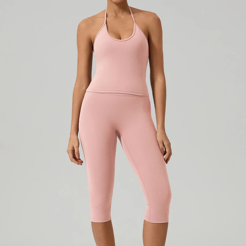Eine Frau trägt ein zweifaches pinkes Yoga-Activewear-Set aus Tanktop und Leggings.