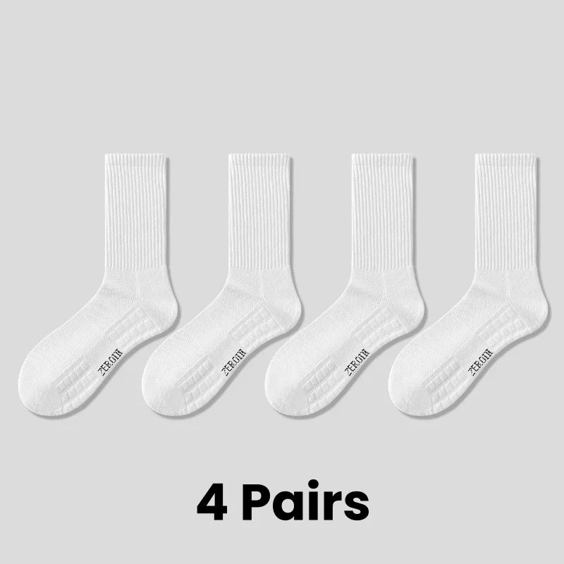 Four pairs of white breathable sports performance socks laid out on a light gray background.