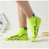 A pair of bright lime green sports socks with black text are displayed on a white surface.