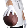 Una mano con guantes deportivos blancos sostiene un balón de rugby marrón contra una camiseta blanca.