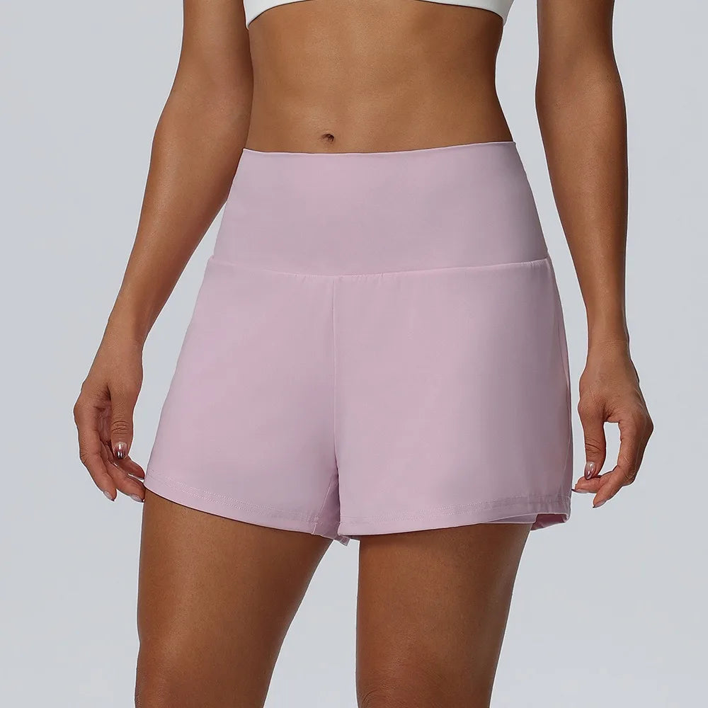 Eine Frau modelliert leichte rosa schnelltrocknende sportliche Shorts von hinten.